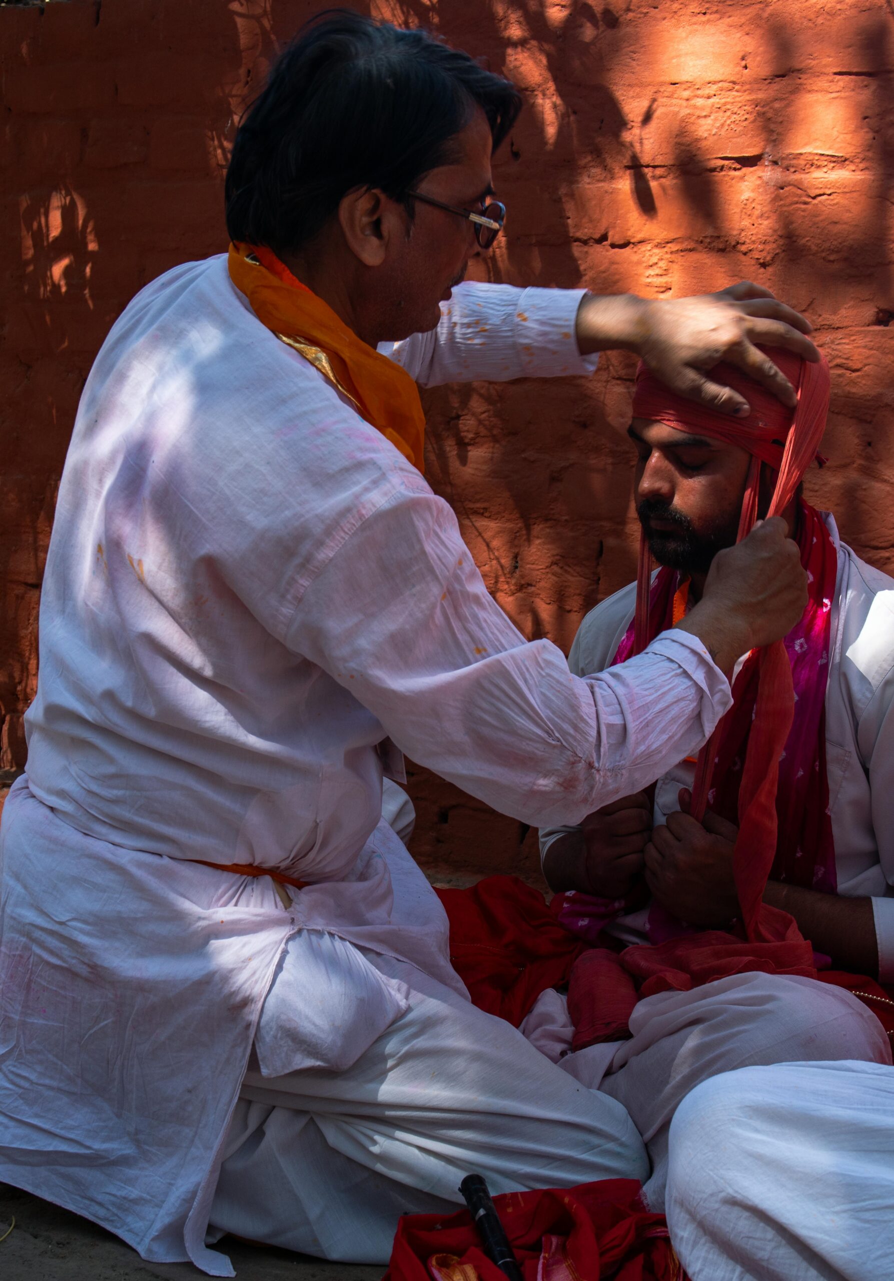 Men engaged in traditional turban tying during a cultural festival in Vrindavan, India.